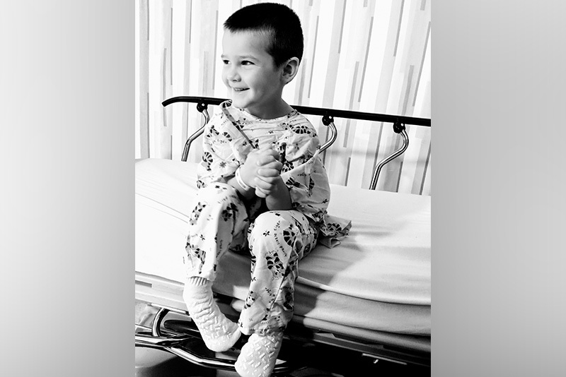 Smiling boy sits on hospital gurney