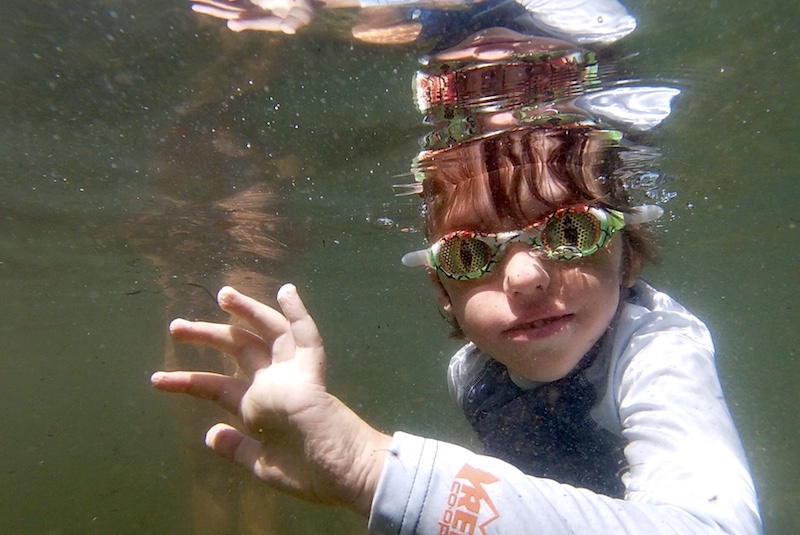 Boy wears goggles while swimming