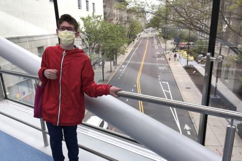 Boy having spinal fusion surgery stands on pedestrian bridge crossing Longwood Avenue
